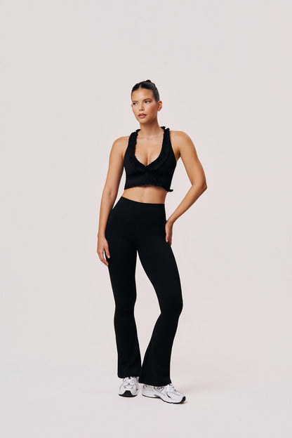 Woman wearing a black athletic outfit on a light gray background